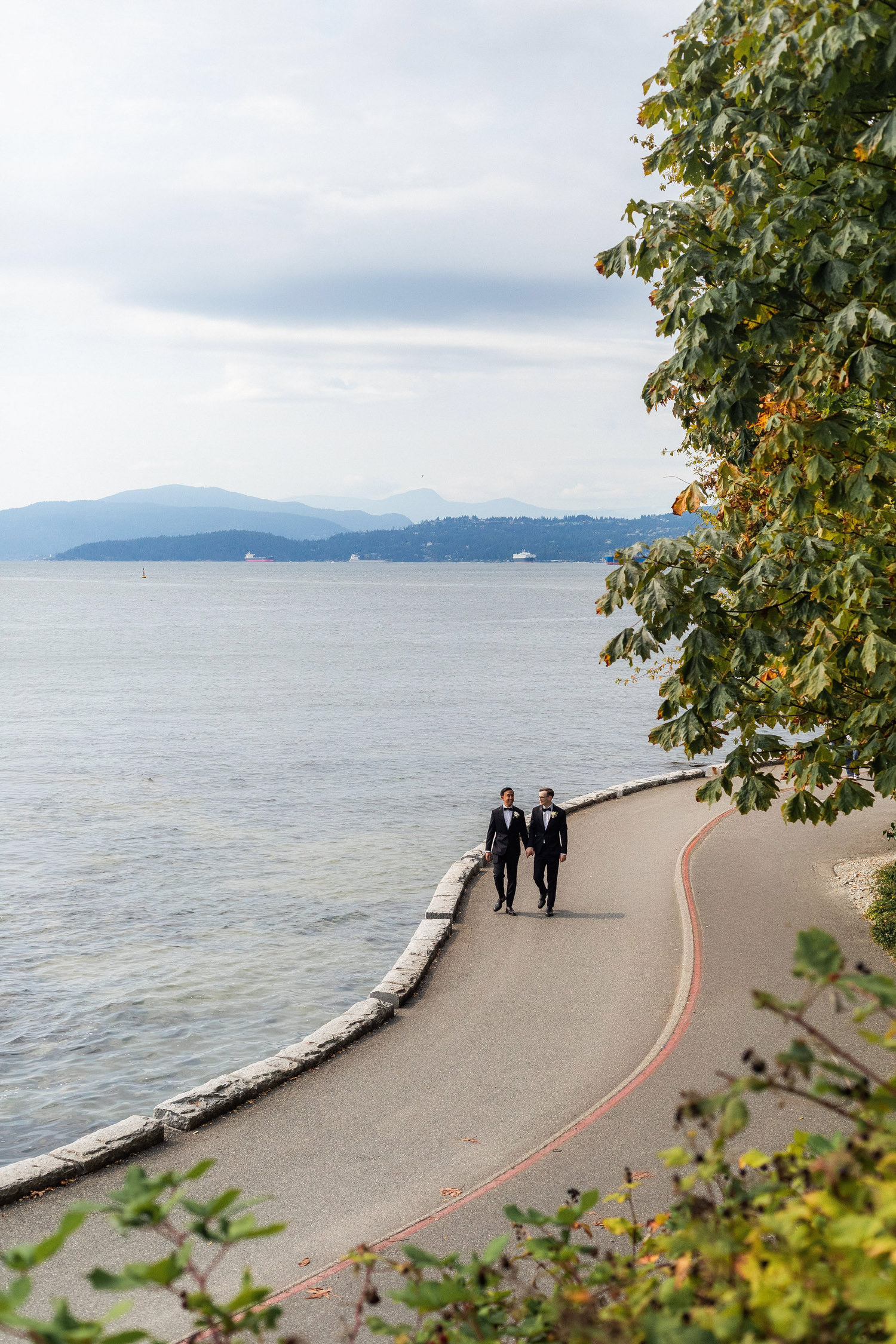 gay grooms walking on sea wall at stanley park