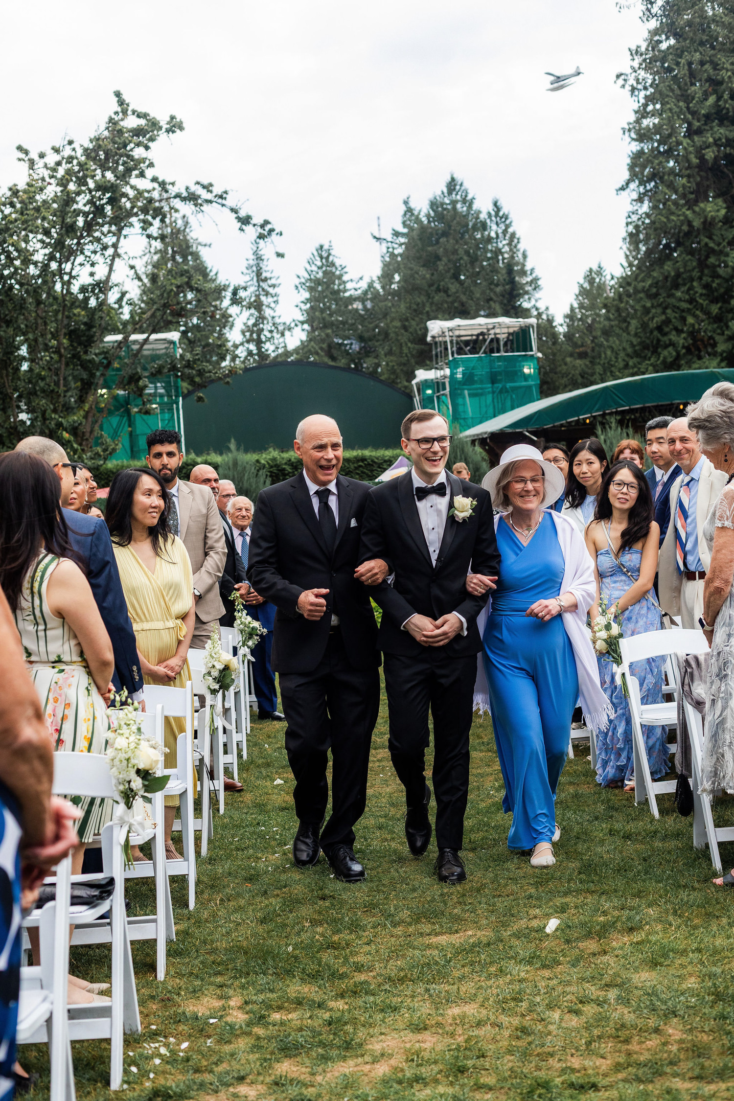 groom walks with family down aisle