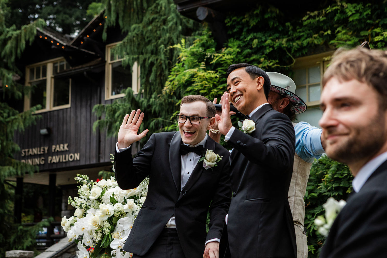 grooms wave to guests at wedding ceremony at stanley park pavilion